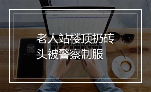老人站楼顶扔砖头被警察制服
